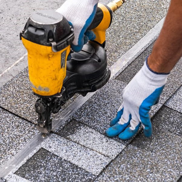 A man installing shingles on a roof that needed repair in Salem Oregon.